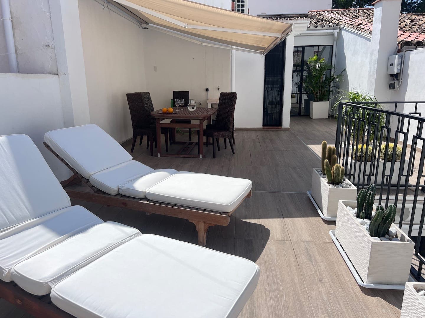 Roof terrace with awning, sun loungers and dining set